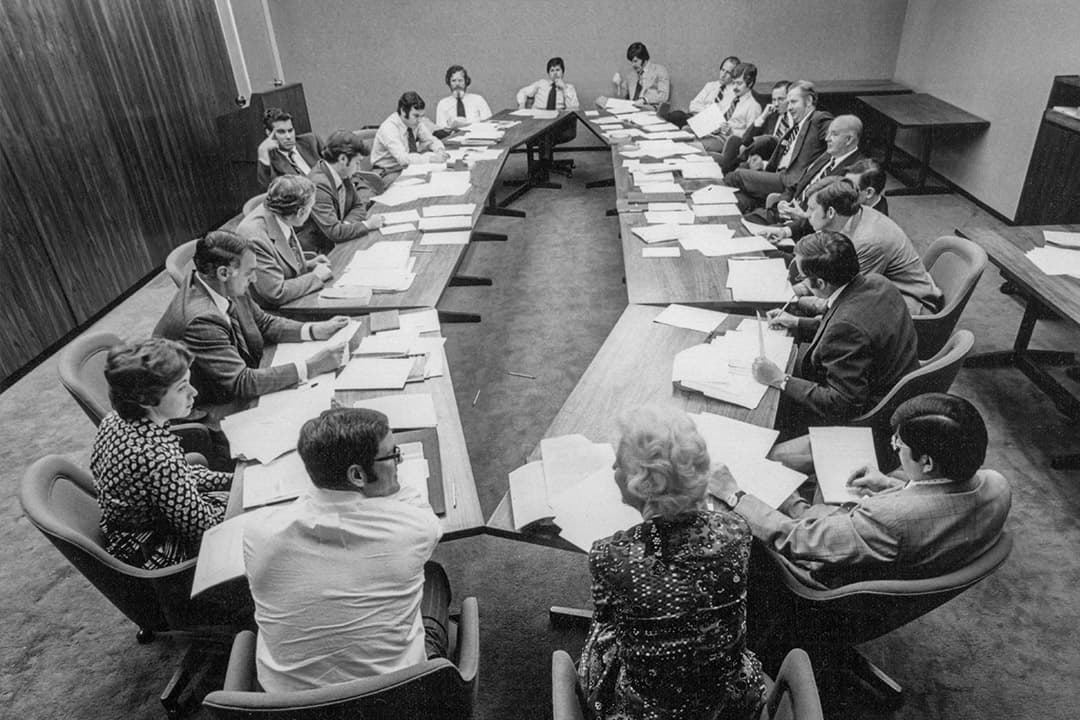 A 1973 committee meeting around a conference table